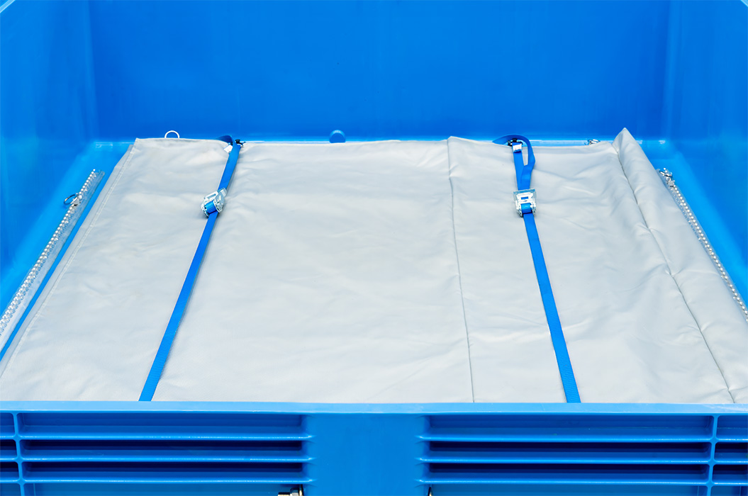Una cassetta di plastica blu con fondo in tela cerata grigia e cinghie blu.