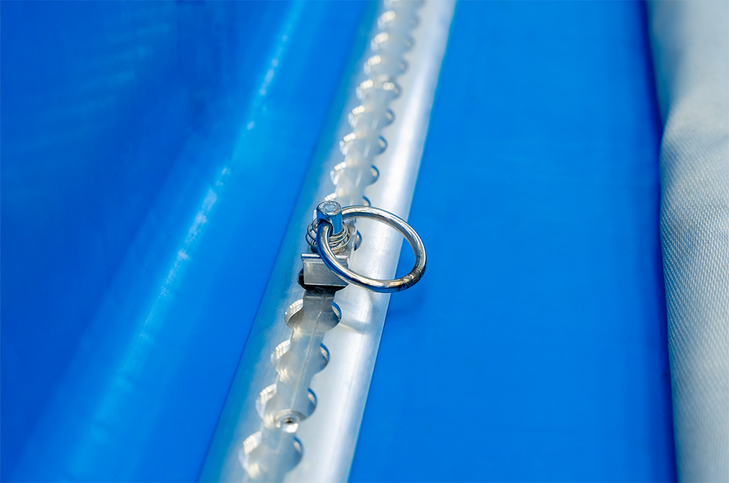 Un anello d'argento giace su una superficie blu e ruvida.
